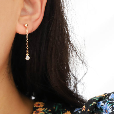 Woman wearing gold chain earrings