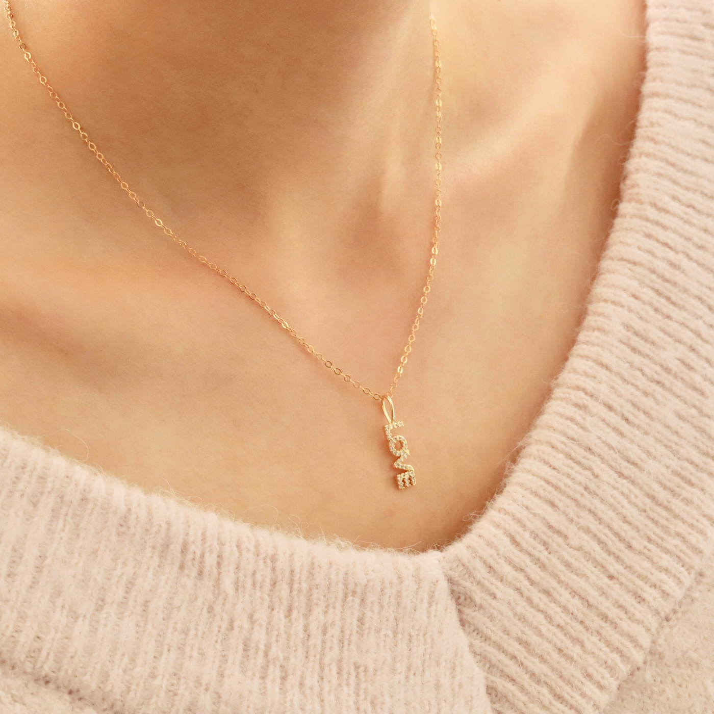 Woman wearing gold letter necklace 