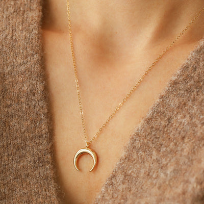 Woman wearing gold pendant necklace